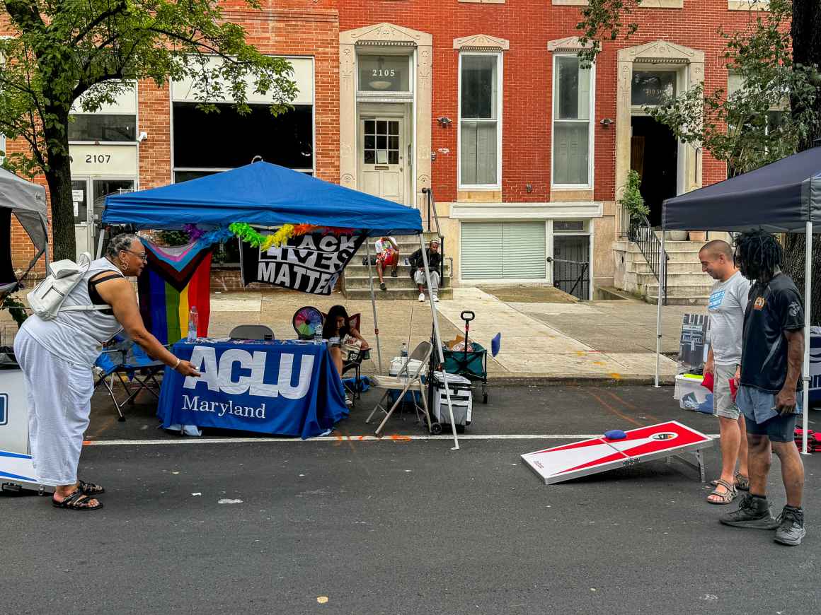 Dana Vickers Shelley and Sergio Espana playing corn hole at the ACLU of Maryland table at Baltimore Trans Pride.