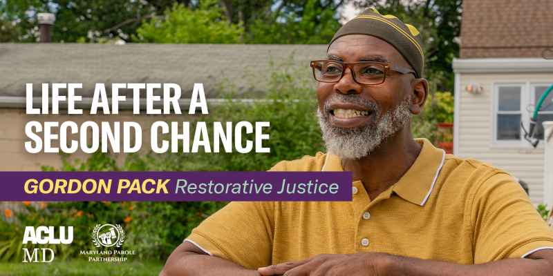Life After a Second Chance series number 3 with Gordon Pack who talks about restorative justice. Gordon is a Black man standing outside in front of flowers. He has a smile on his face and is leaning with his arms crossed.